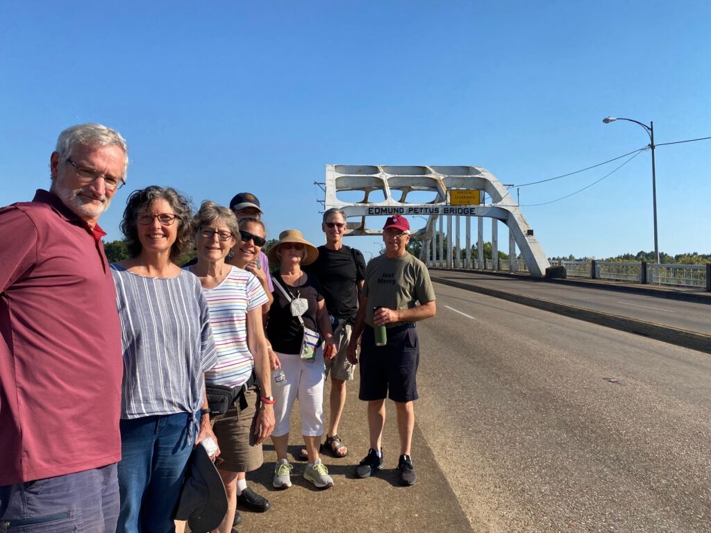 Members of Community Mennonite Church's Just Peace Pilgrimage group stand before the Edmund Pettus Bridge in Selma, Alabama. From left to right: Art Stoltzfus, Meribeth Kraybill, Betty Shenk, Rene Hostetter, Isaac Witmer, Ruth Zimmerman, Keaton Shenk, and Earl Zimmerman. Photo provided.