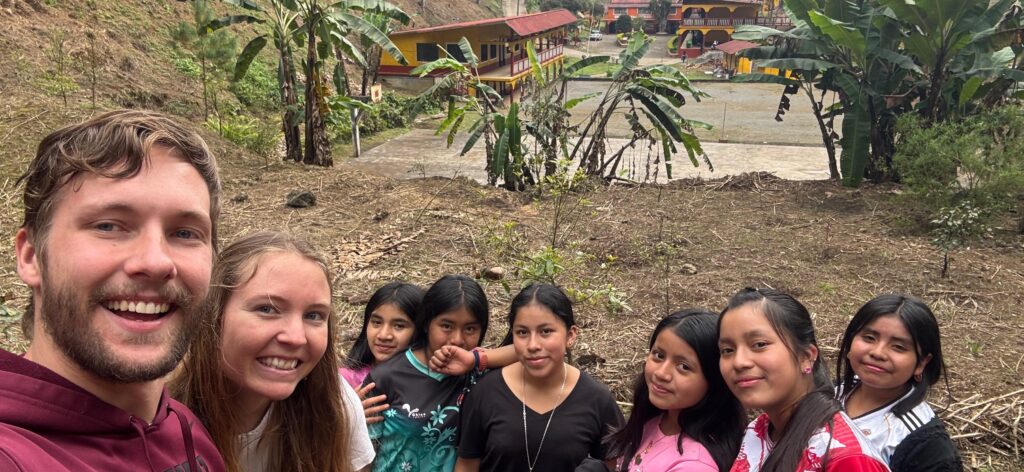 The segundo basico students pose for a photo in the avocado grove on the Q’eqchi’ Bezaleel Mennonite Educational Center campus.