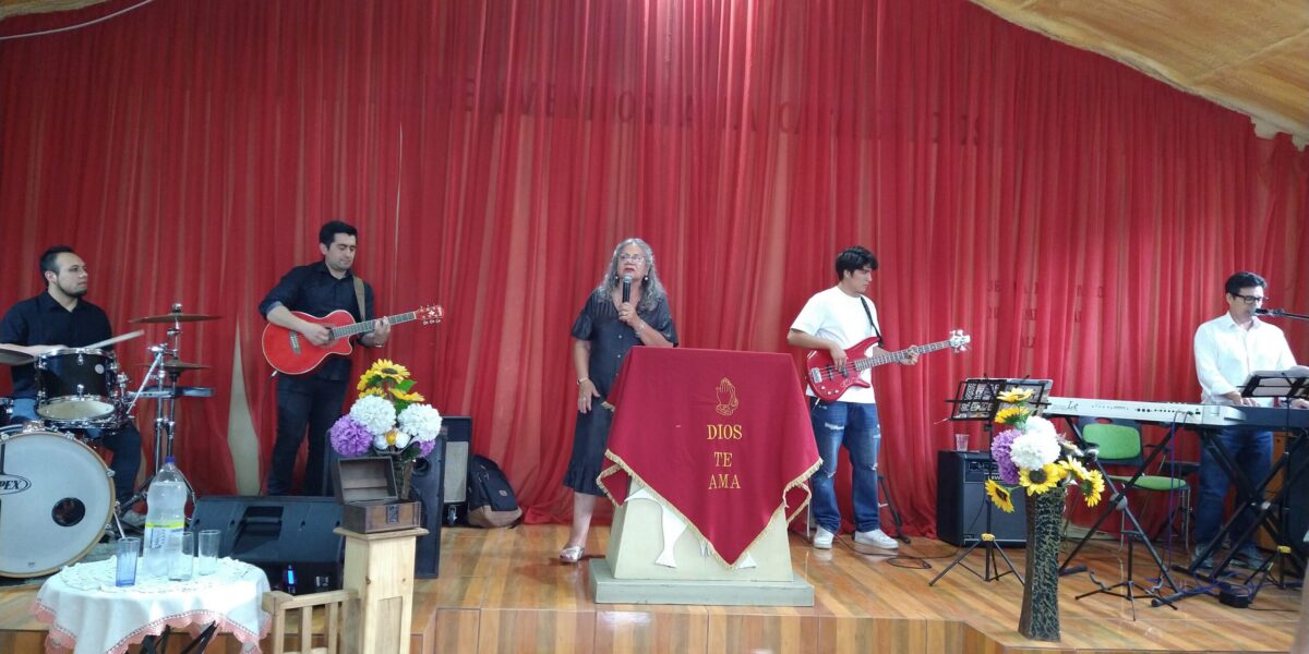 Gladis Silva leads singing at the united worship service of the Iglesia Evangélica Menonita de Chile (IEMCH).