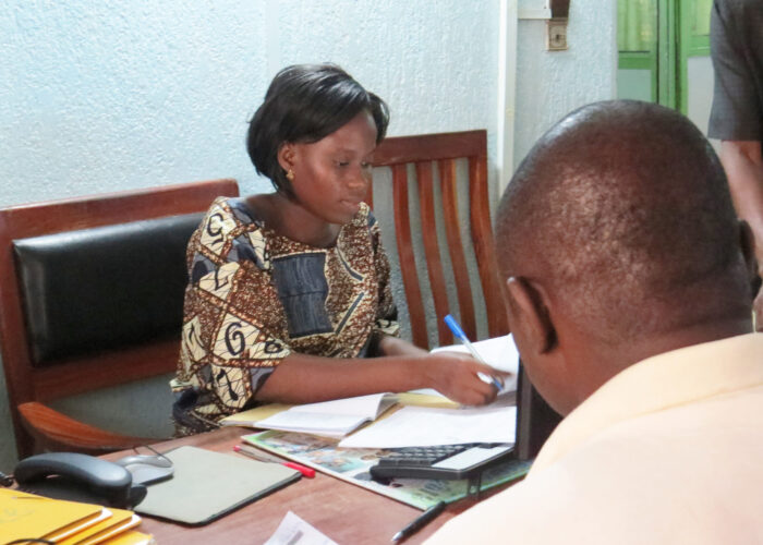 Liduine Tokoudagba helps a PEBCo client open an account. Photo by Lynda Hollinger-Janzen. Download full-resolution image.