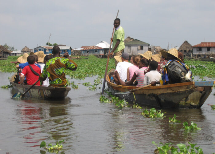Inhabitants of Ganvié introduce a North American delegation to their village built on stilts over Lac Nokoué