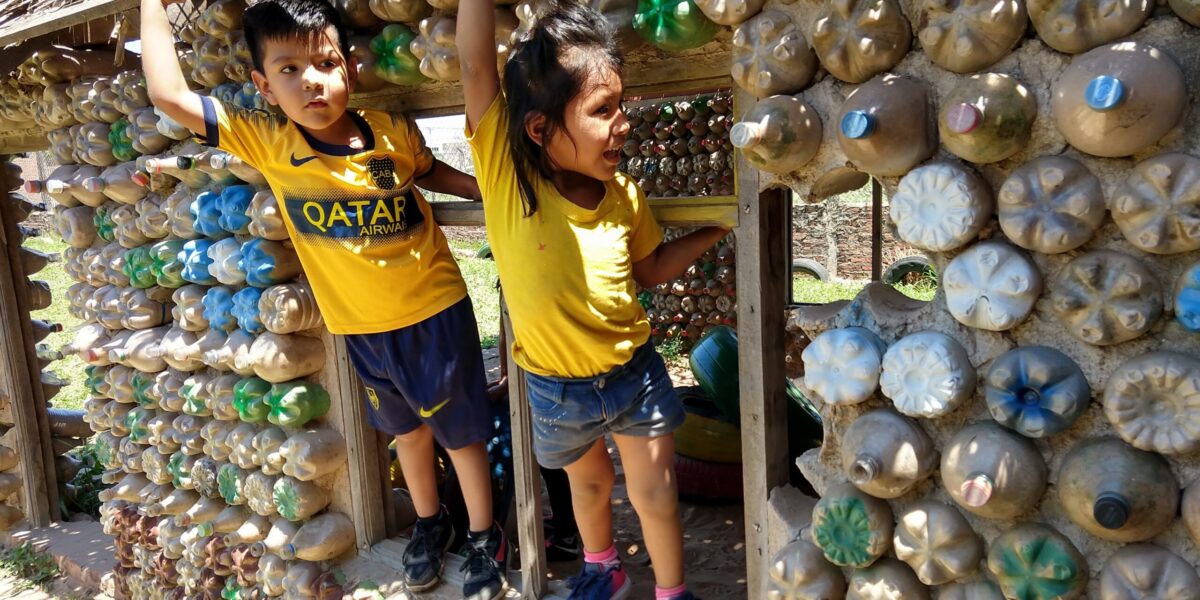 ​Children at Samuelito Daycare center prior to the pandemic enjoy climbing on their play house made of recycled materials. Families helped gather the materials and the center won a contest in the city of Santa Cruz for their environmentally friendly construction. Now some of the same children