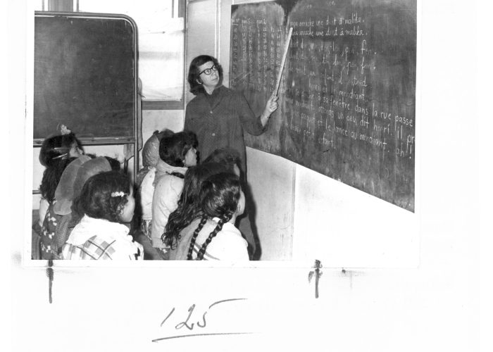 Her second term in Algeria, Marian Hostetler is pictured in 1965 teaching a class of 77 Chaouia girls, to read (The Chaouia tribal confederation come from a variety of Arab and Berber origins). She also taugh writing and arithmetic.