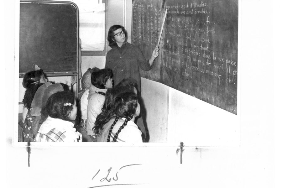 Her second term in Algeria, Marian Hostetler is pictured in 1965 teaching a class of 77 Chaouia girls, to read (The Chaouia tribal confederation come from a variety of Arab and Berber origins). She also taugh writing and arithmetic.