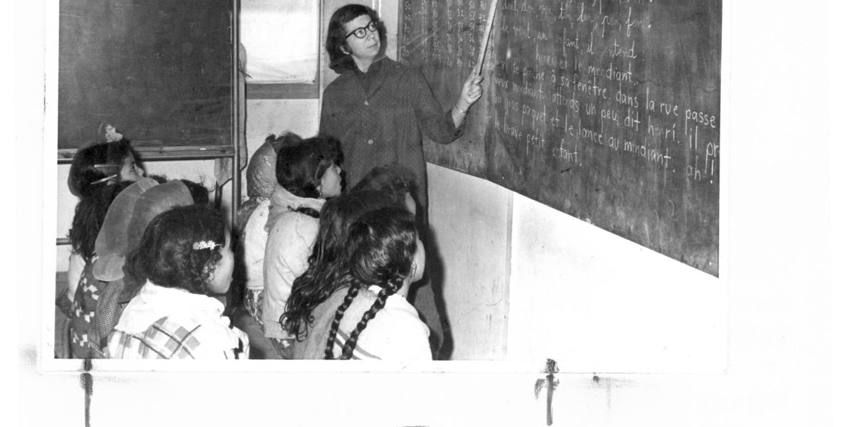 Her second term in Algeria, Marian Hostetler is pictured in 1965 teaching a class of 77 Chaouia girls, to read (The Chaouia tribal confederation come from a variety of Arab and Berber origins). She also taugh writing and arithmetic.