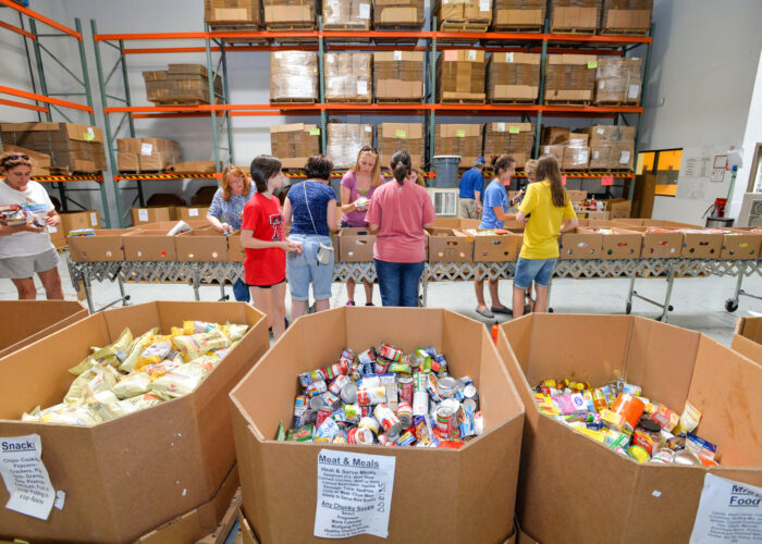 Youth volunteers fill boxes of food at St. Mary’s Food Bank in Phoenix as part of their servant project during Mennonite Church USA Convention. Download full-resolution image.