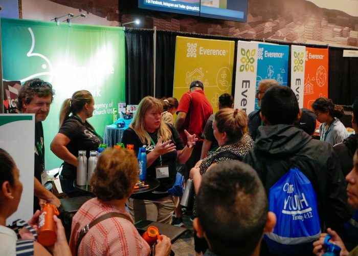 Susan Nisly (center) talks with visitors at the MMN booth on Tuesday