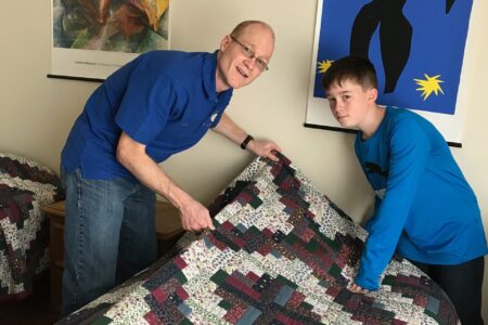 ​Eric and Nathan Miller make a bed at the International Guest House in Washington