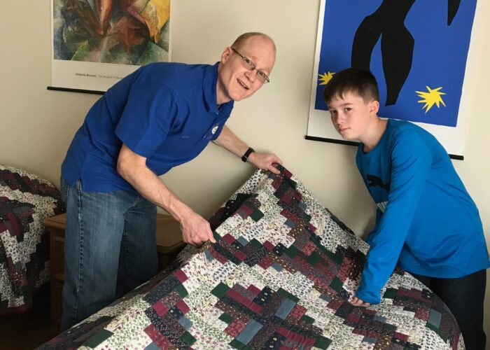 ​Eric and Nathan Miller make a bed at the International Guest House in Washington