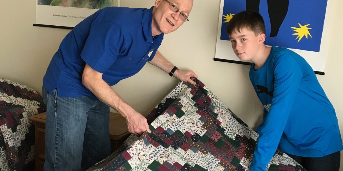 ​Eric and Nathan Miller make a bed at the International Guest House in Washington