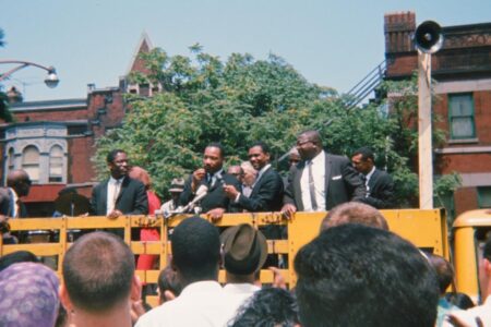 ​Martin Luther King, Jr. speaks to a crowd before a march in Chicago. Photo by Neill von Gunten.
