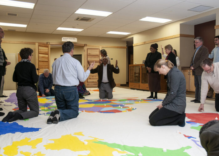 The Council on International Anabaptist Ministries (CIM) participants pray for the world during an annual gathering held 2018 at the Mennonite offices in Elkhart