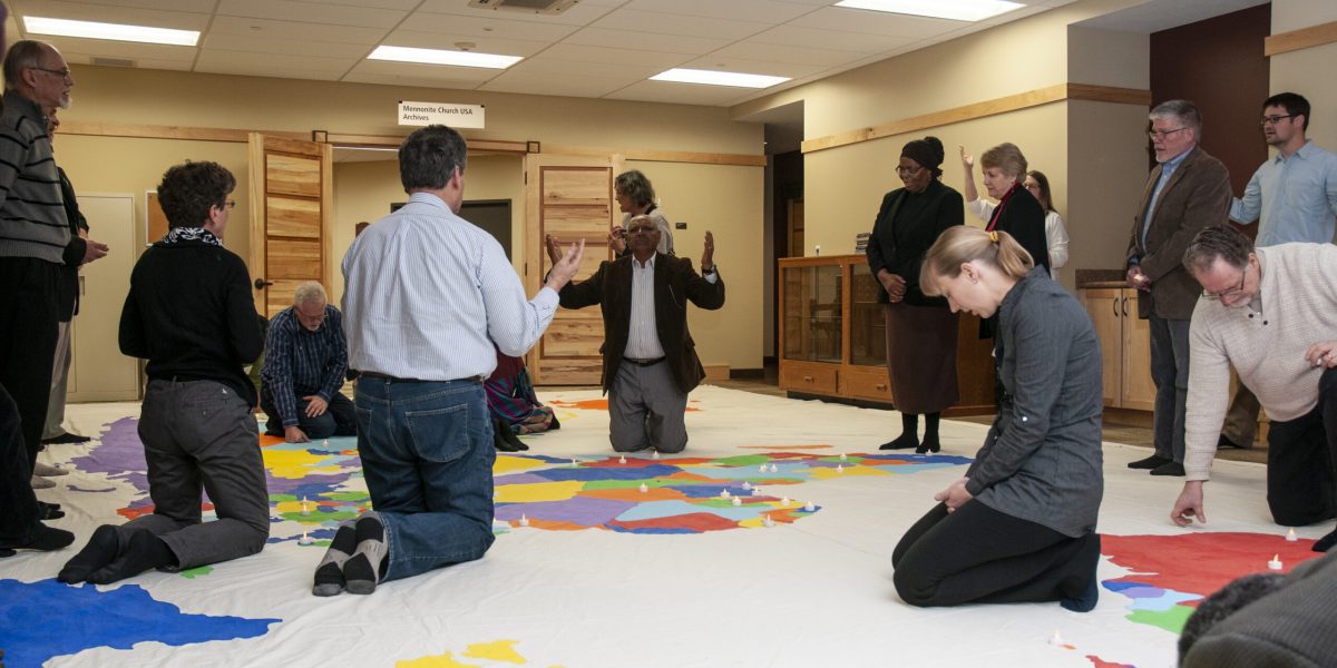 The Council on International Anabaptist Ministries (CIM) participants pray for the world during an annual gathering held 2018 at the Mennonite offices in Elkhart
