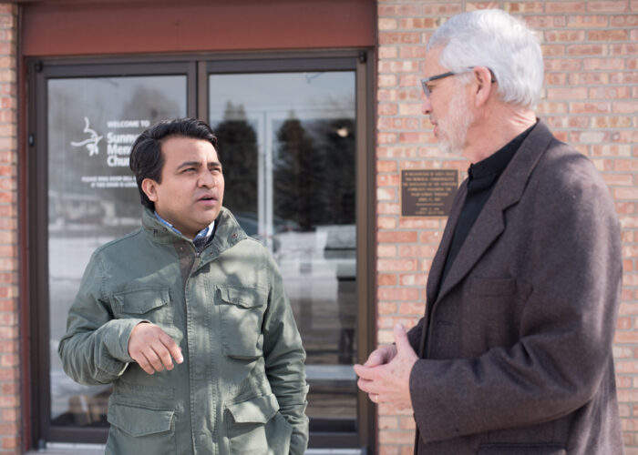 Naun Cerrato and Charles Geiser talk outside Sunnyside Mennonite Church. Photo by David Fast.