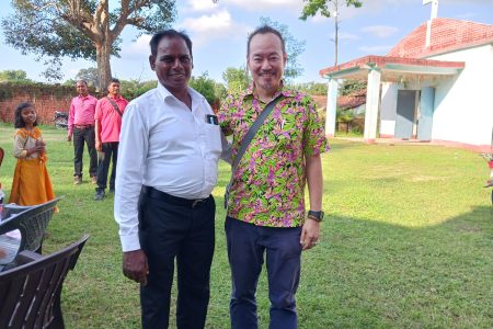 Rev. Suleman Tigga and Andi Santoso in front of Bihar Mennonite Mandli church, Bathet, India.