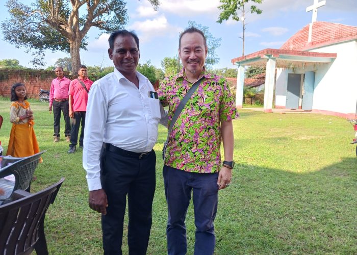 Rev. Suleman Tigga and Andi Santoso in front of Bihar Mennonite Mandli church, Bathet, India.
