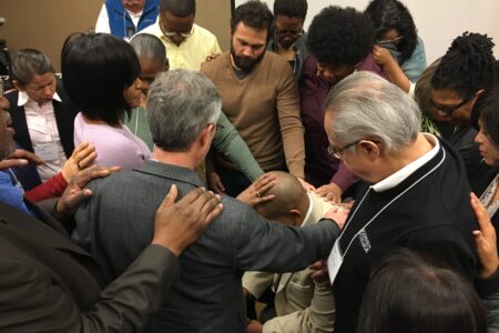 Fellow participants at Hope for the Future 2018 pray over Glen Guyton