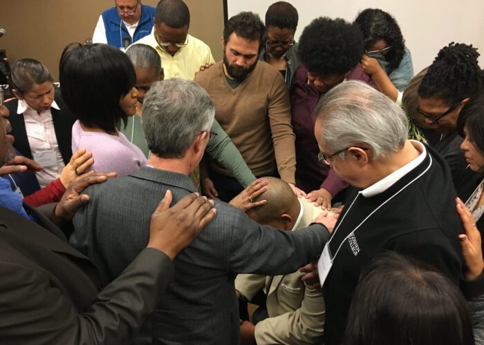Fellow participants at Hope for the Future 2018 pray over Glen Guyton