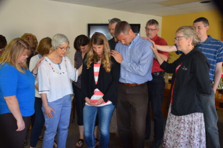 ​Mennonite Mission Network staff members pray with DeeDee and Mark Landes during a May 29 chapel in Newton