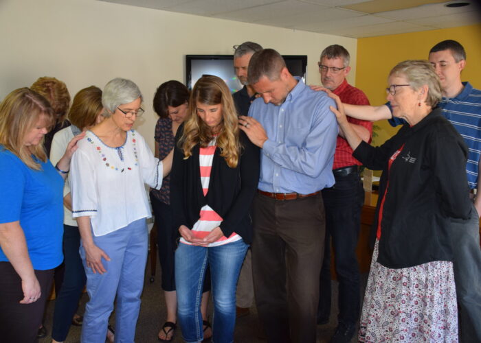 ​Mennonite Mission Network staff members pray with DeeDee and Mark Landes during a May 29 chapel in Newton