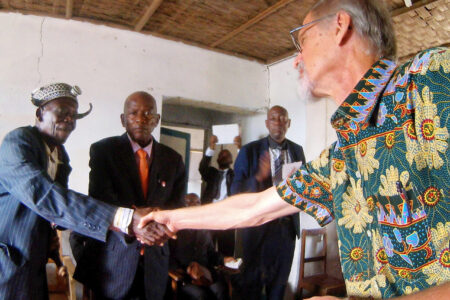 One of the traditional dignitaries from the surrounding region shakes Rod Hollinger-Janzen's hand during the ceremony of confession and reconciliation in Kandale