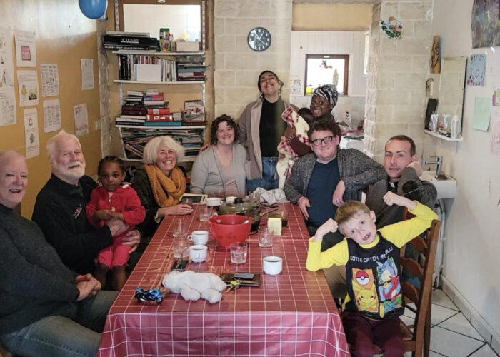 ​Heba (standing center) and Rachel and Joseph Givens (seated center) share table fellowship with board members