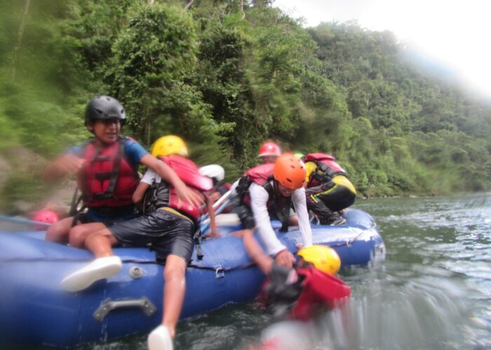 ​Cofan youth recover after passing through a rapid and losing a few rafters overboard. Photo provided by Jane and Jerrell Ross Richer. 