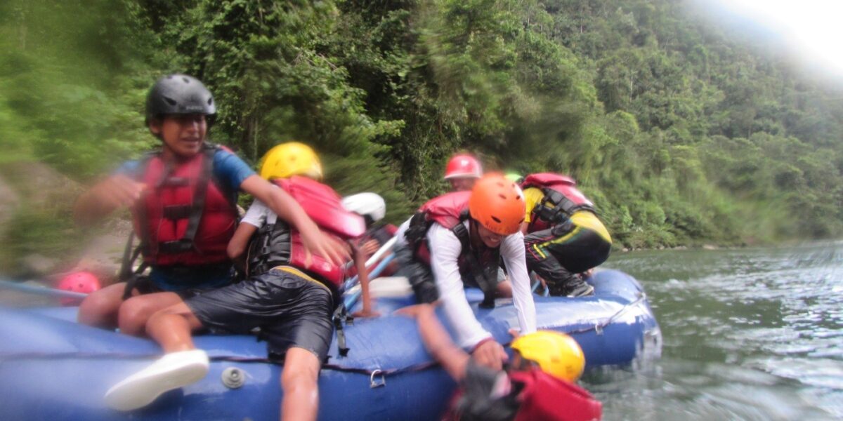 ​Cofan youth recover after passing through a rapid and losing a few rafters overboard. Photo provided by Jane and Jerrell Ross Richer. 