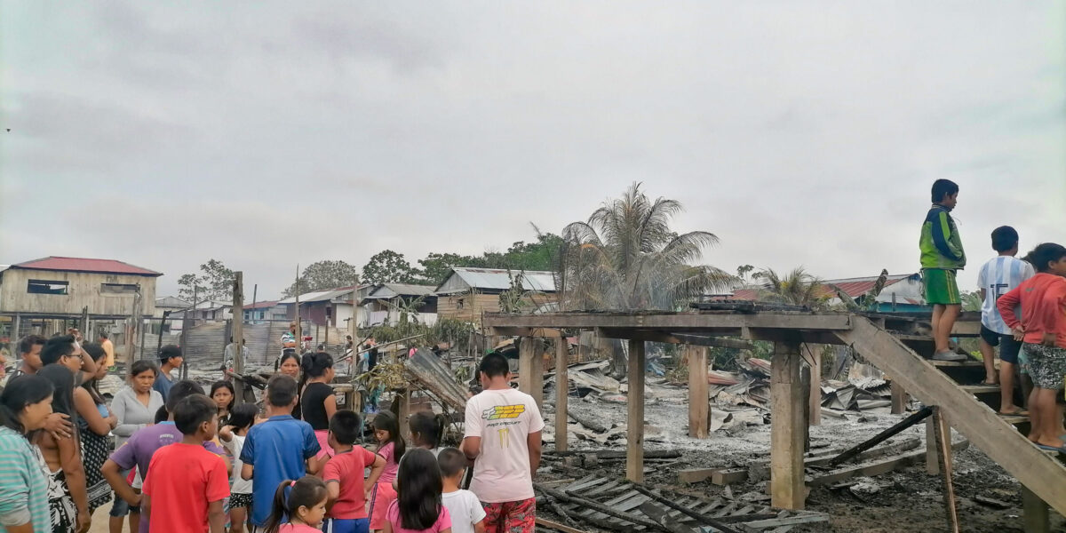 ​Adults and children living on Isla Iquitos in Peru survey the damage at the site where their church and five houses burned to the ground the night of August 29. Children stand on the stairs that once led to their space for worship and learning. Photo by Juan Carlos Moreno.