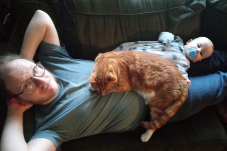 Travis Duerksen, his son, and Ollie the cat. Photo by Erica Stoltzfus.