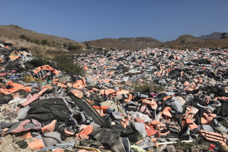 ​A doll (lower left corner) in the remnants of improvised rafts washed up on the shores of Lesbos symbolizes lives lost. Photographer: Sophie Lapp Jost