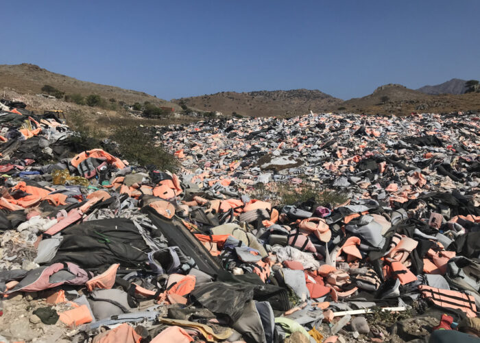 ​A doll (lower left corner) in the remnants of improvised rafts washed up on the shores of Lesbos symbolizes lives lost. Photographer: Sophie Lapp Jost