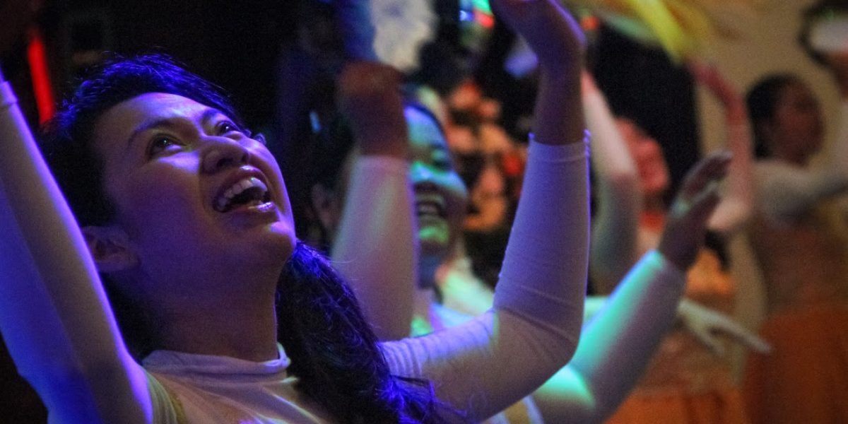 Analia Susanto, the treasurer of Maranatha church, dances for joy with others during worship at Maranatha Church in Indonesia.