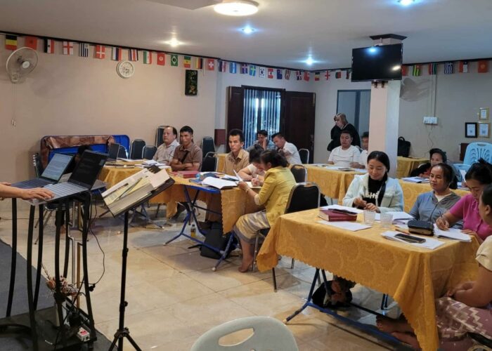 Jonah Yang (left, on stage) leads a session on leadership training during a Compassionate Care retreat in Southeast Asia. Photo by Memee Yang.