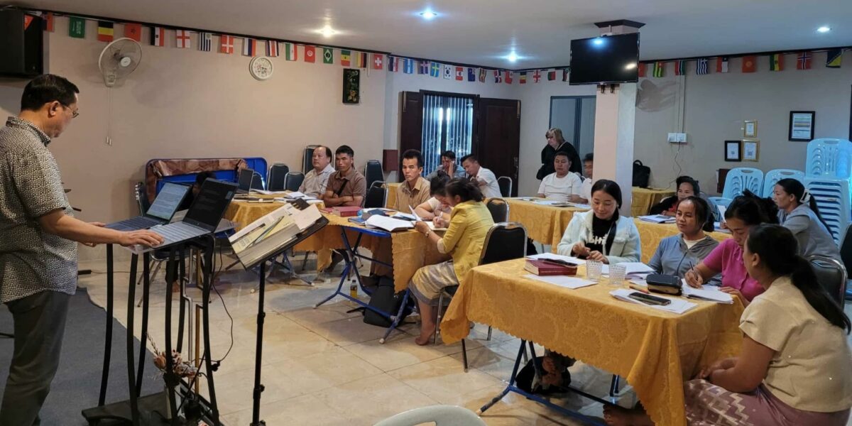 Jonah Yang (left, on stage) leads a session on leadership training during a Compassionate Care retreat in Southeast Asia. Photo by Memee Yang.