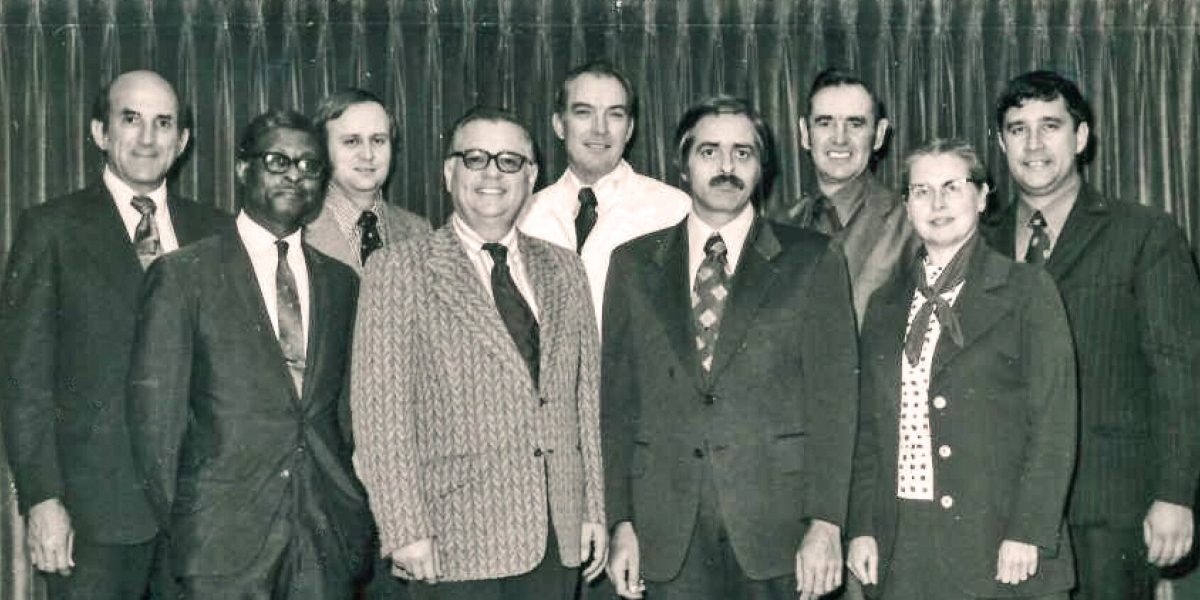 A 1973 photograph of the Mennonite Board of Missions. Back row, left to right: Louis Strite, Robert Summers, Jim Detweiler, James Mullet, Gerald Good. Front: Leamon Sowell, Sam Jantzen, Donald Yoder, Doris Kramer. Photo by Alvin Hostetler.