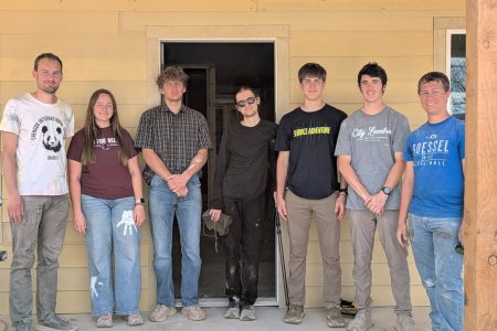 The Service Adventure teams in front of the house they helped construct with Mennonite Disaster Service. Left to right: Christian Stoltzfus (Colorado Springs unit co-leader), Adriana Duerksen, Michael Bergen, Mir Knego (Anchorage unit leader), Ruben Veigel, Ian Unzicker, Sam Abrahams. Photo provided.