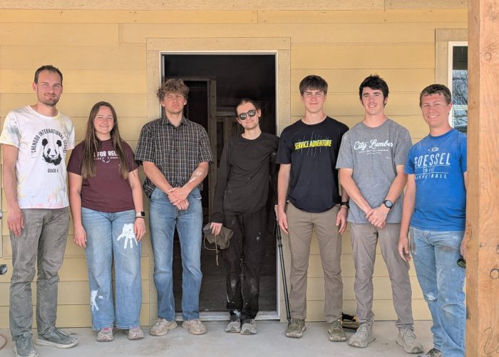 The Service Adventure teams in front of the house they helped construct with Mennonite Disaster Service. Left to right: Christian Stoltzfus (Colorado Springs unit co-leader), Adriana Duerksen, Michael Bergen, Mir Knego (Anchorage unit leader), Ruben Veigel, Ian Unzicker, Sam Abrahams. Photo provided.