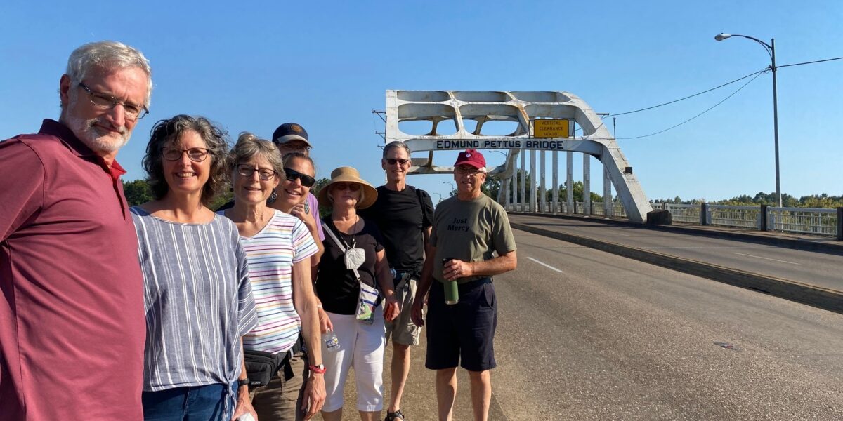 Members of Community Mennonite Church's Just Peace Pilgrimage group stand before the Edmund Pettus Bridge in Selma, Alabama. From left to right: Art Stoltzfus, Meribeth Kraybill, Betty Shenk, Rene Hostetter, Isaac Witmer, Ruth Zimmerman, Keaton Shenk, and Earl Zimmerman. Photo provided.