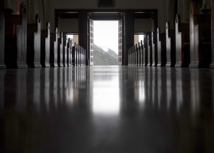 Desaturated image of empty church aisle.