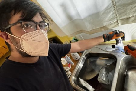Juan Witmer, a participant with the 2025-26 Tucson MVS unit, works on a client's sink through his placement with CHRPA. Photo by Juan Witmer.