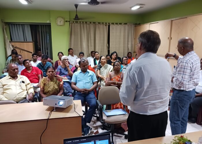 David Boshart and Vikal Pravin Rao look on while Sangita Tigga of Bihar Mennonite Mandli conference reports from a small group.