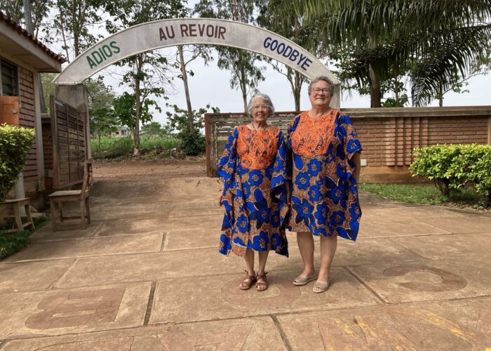 From left, Maria and Barb Thuma pose after Sunday church service on their last day in Allada. Their bespoke dresses were gifted to them the day before as a going-away present from La Casa Grande Director Bienvenu Kadja and his wife Chimene Kadja, a member of the staff.